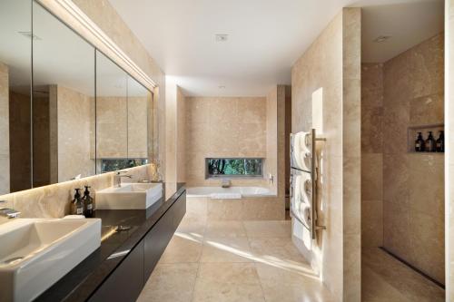 ein Badezimmer mit zwei Waschbecken und einer Badewanne in der Unterkunft Oraka Lakeside Retreat by Sotheby's Luxury Rental Homes in Queenstown Airport
