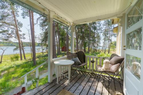 a screened porch with a table and chairs and a view of the water at Honkala in Turku