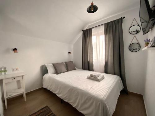 a small bedroom with a white bed and a window at Casa Ambra in Sadova