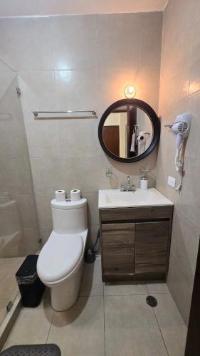 a bathroom with a toilet and a sink and a mirror at Modern and Centrally Located House in Monterrey