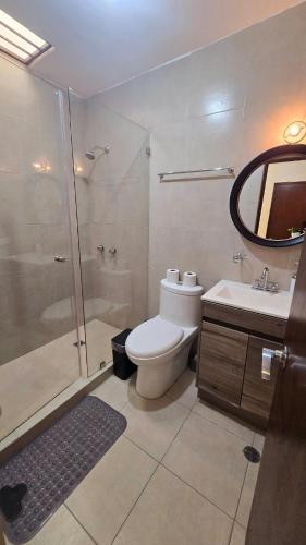 a bathroom with a shower and a toilet and a sink at Modern and Centrally Located House in Monterrey