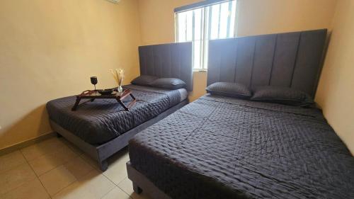 a bedroom with two beds and a table in it at Modern and Centrally Located House in Monterrey