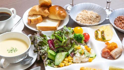 a table with a plate of food with a salad and bread at APA Hotel Kobe Sannomiya Ekimae in Kobe