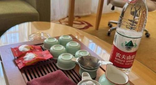 a table with a bottle and a group of green candles at Vienna Hotel Guangdong Zhaoqing Sihui Tianguangxu in Zhaoqing