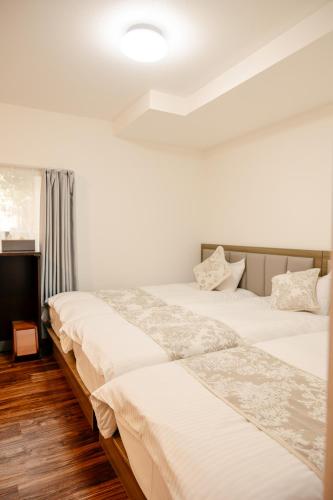 two beds sitting next to each other in a bedroom at X103Nagoya Station area courtyard rental detached house in Nagoya