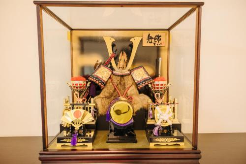 a glass display case with a stuffed animal and helmets at X103Nagoya Station area courtyard rental detached house in Nagoya