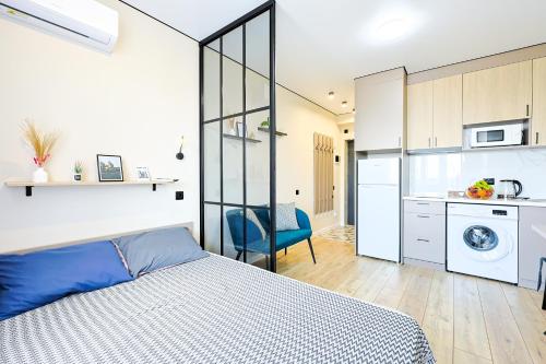 a bedroom with a bed and a kitchen at 1 room apartment CITY PLUS 4 in Almaty
