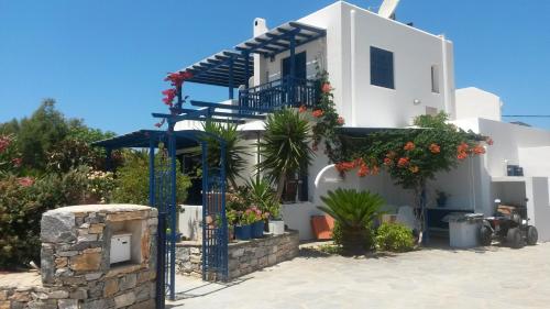 Un edificio blanco con balcón y plantas. en Haus Asterakia, en Aliko Beach
