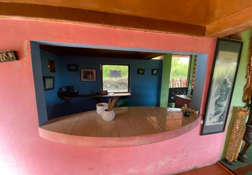 a living room with a pink wall and a table at Roman Sinasi Hotel By Secoms in Tongging