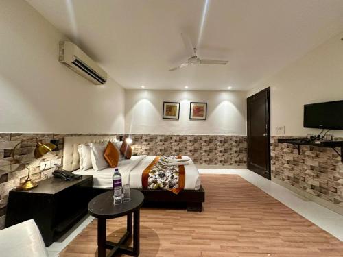 a hotel room with a bed and a tv at Hotel Grand Arcasia Saket- Near PVR Anupam in New Delhi