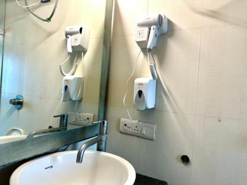 a bathroom with a sink and a mirror at Hotel Grand Arcasia Saket- Near PVR Anupam in New Delhi