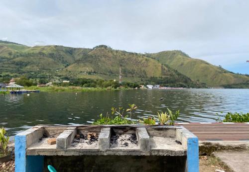 a boat on a lake with mountains in the background at Roman Sinasi Hotel By Secoms in Tongging