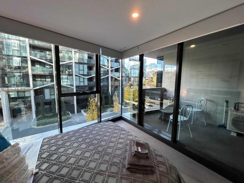a bedroom with a bed and large glass windows at 2BR-2BR-1Car-CBD-Pool-Shopping in Canberra