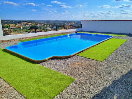 a swimming pool on the roof of a house with grass at Villa com Piscina Privada para 6 Pessoas Casa dos Filhos dos Padeiros in Figueira e Barros