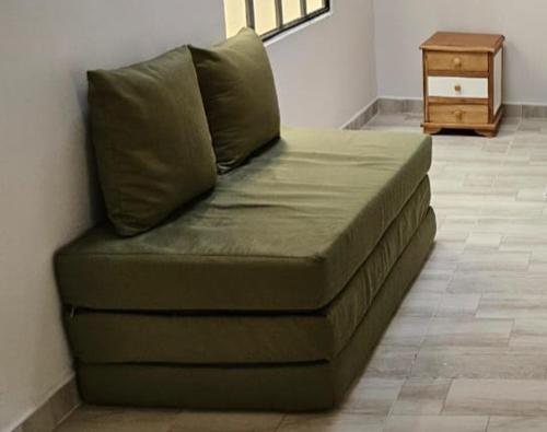 a green couch sitting in a room with a table at Apartaestudio tipo Loft tranquilo cerca al Parque in Armenia