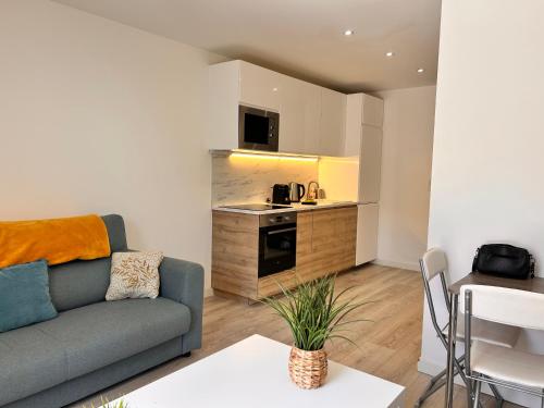 un salon avec un canapé et une cuisine dans l'établissement Rebeca - 4 pers Standing - Hyper centre -Terrasse, à Saint-Raphaël