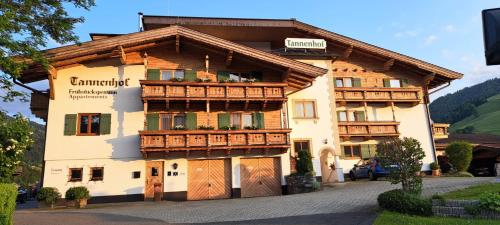 a large building with wooden doors and windows at Frühstückspension Tannenhof in Kirchberg in Tirol