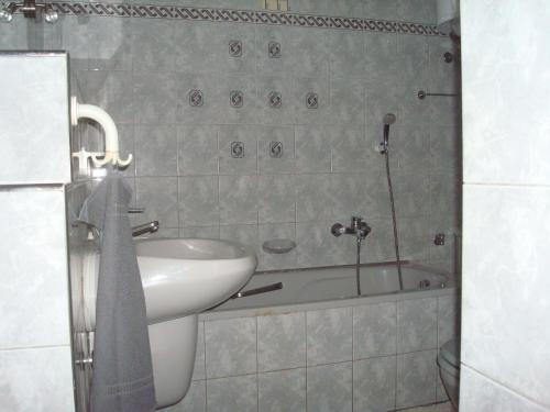 bagno con lavandino e vasca di Kornél Apartman a Siófok