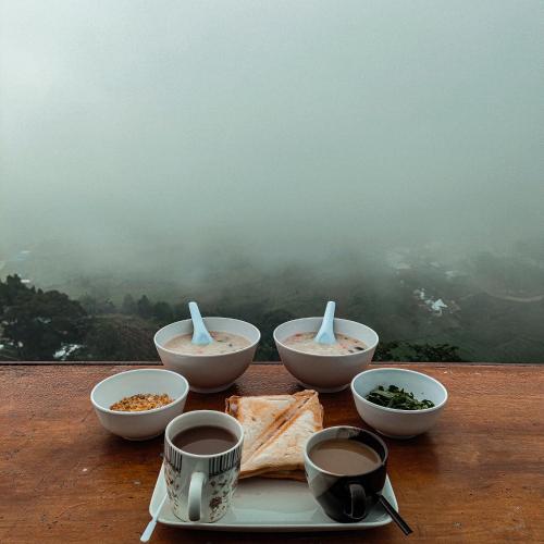 ein Teller mit Essen und Schüsseln mit Essen auf einem Tisch in der Unterkunft Phu Boek Fah Camping in Mon Jam