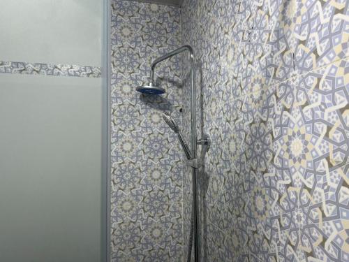 y baño con ducha y pared de azulejos. en Boutique Hostel, en Samarkand