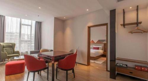 a living room with a table and chairs and a bedroom at Borrman Hotel Guilin Railway Station Two Rivers and Four Lakes in Guilin