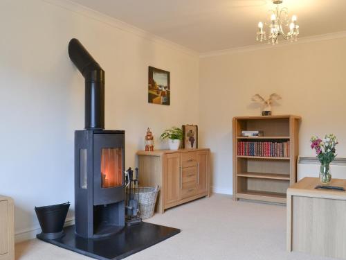 a living room with a wood stove in it at Riverside in Kilmelfort