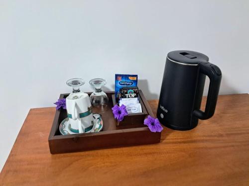 a wooden tray with a coffee maker and glasses on a table at Lonthar B&B - Adults Only in Riung