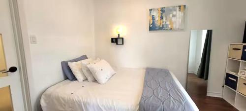 a bedroom with a bed with white sheets and pillows at Great Location -Mural, Barn and Corridor -1 Bed 1Bath Apartments! in Windsor