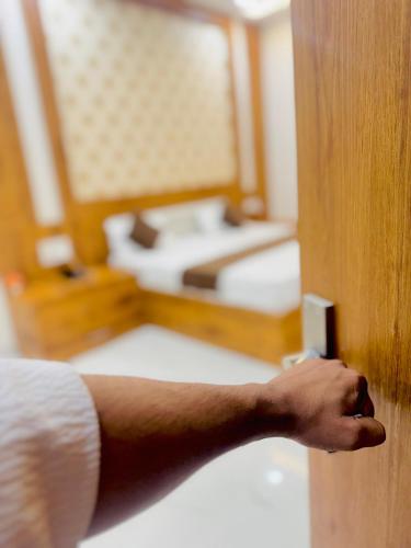 a persons hand opening a door to a bedroom at The Lavish Hotel in Pīrthala