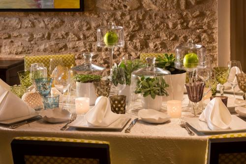 a table with a white table cloth with plates and glasses at Hotel De France in Angerville