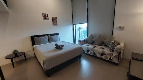 a small bedroom with a bed and a couch at KL Sentral Loft, EST Bangsar #1, LRT in Kuala Lumpur