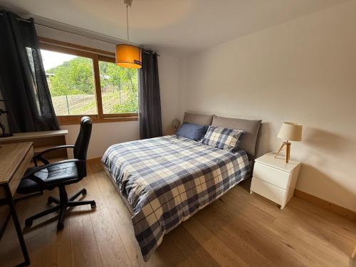 a bedroom with a bed and a desk and a window at Casa Vitale Villard du Planay in Planay