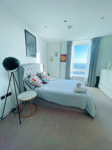 a bedroom with a large bed and a large window at Luxury 1-Bedroom Apt with Stunning London Views in Barking