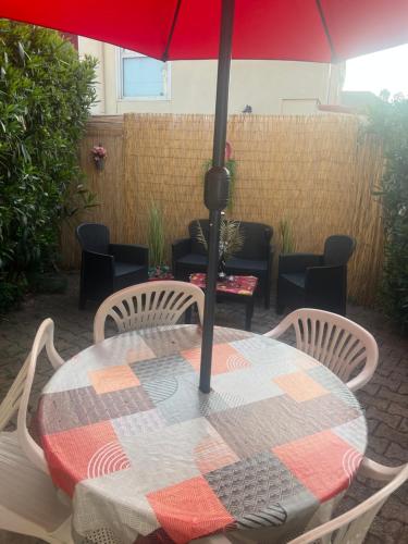 a table with an umbrella on a patio at Location d'un pavillon de vacances in Marseillan