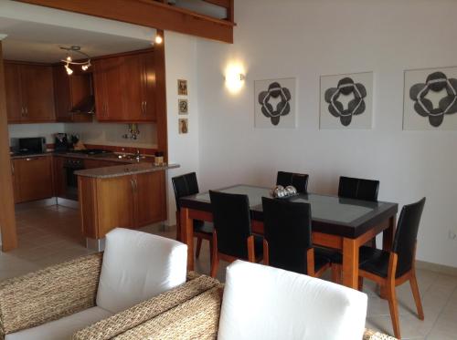 een keuken en eetkamer met een tafel en stoelen bij Casa Trinta - Praia da Arrifana in Praia da Arrifana