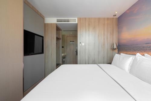 a bedroom with a large bed and a flat screen tv at 青年阳光酒店有限公司 in Xiamen