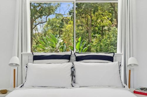 a bedroom with a bed with a large window at Sunset Palms in Palm Beach