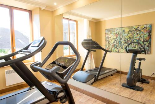 a gym with two exercise bikes and a mirror at Hotel De France in Angerville