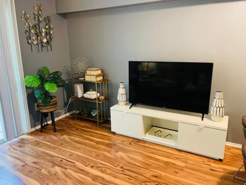 a living room with a flat screen tv on a white entertainment center at Welcome Home in Hyattsville