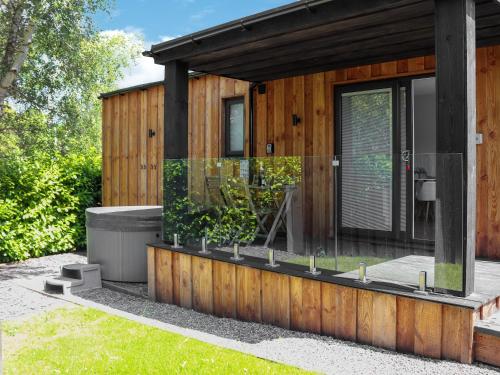 a wooden house with glass windows and potted plants at Padarn Lodge - Uk47605 in Caernarfon