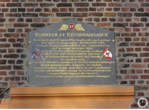 une plaque sur un mur de briques avec un signe dans l'établissement Logement Omissy, 