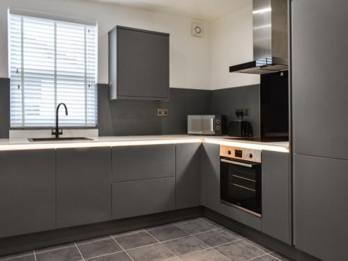 Una cocina con gabinetes blancos y un fregadero. en Bay View, en Morecambe