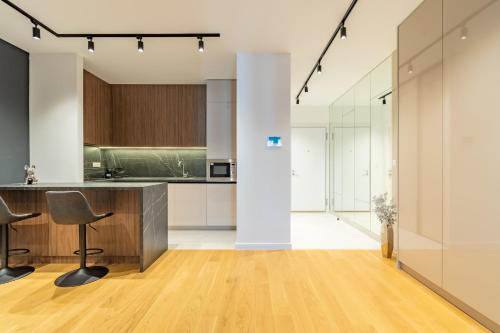 a kitchen with a counter and chairs in a room at Park Vila Apartments in Belgrade