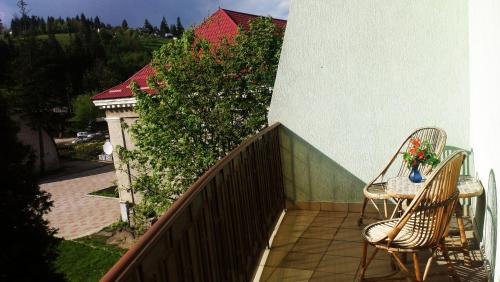 a balcony with two chairs and a table with flowers at Laguna in Slavske