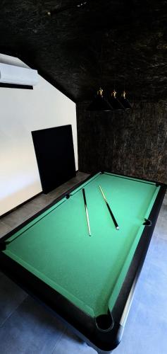 a green pool table with two cue sticks on it at Czarni Górale in Barcice