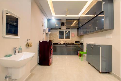 a bathroom with a sink and a kitchen with a window at The Sunbird in Kondapur