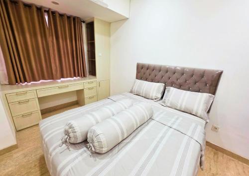 a bedroom with a large bed with a leather headboard at Apartment - 2 bedroom, 3 beds in Medan
