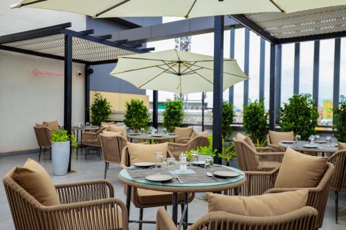 ein Restaurant mit Tischen, Stühlen und Sonnenschirmen in der Unterkunft Sathyam Oasis in Tiruchchirāppalli