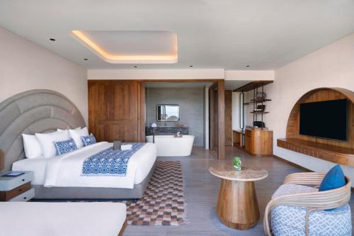 a hotel room with a bed and a television at TUI BLUE Berawa Hotel and Villas in Canggu