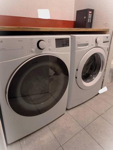 a white washing machine sitting next to a washer at Great Location -Mural, Barn and Corridor -1 Bed 1Bath Apartments! in Windsor